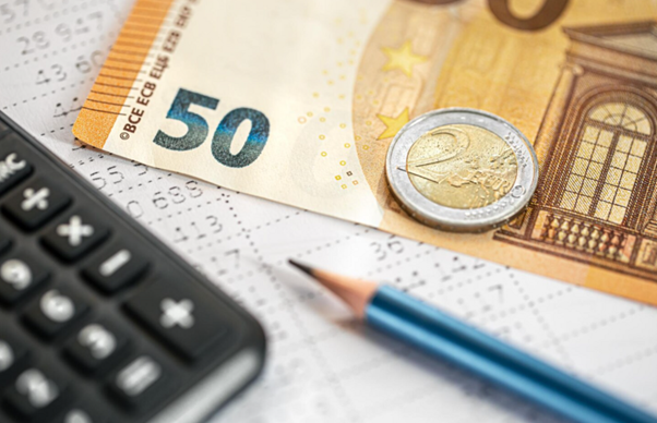 50-eurová bankovka, 2-eurová minca, kalkulačka a ceruzka na finančnom dokumente.